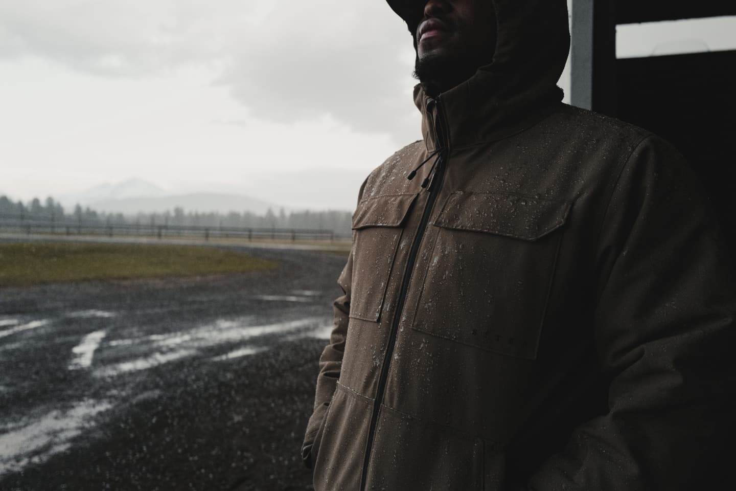 The Grindstone Jacket in Coyote keeping a working man warm and dry in the rain | SITKA Gear